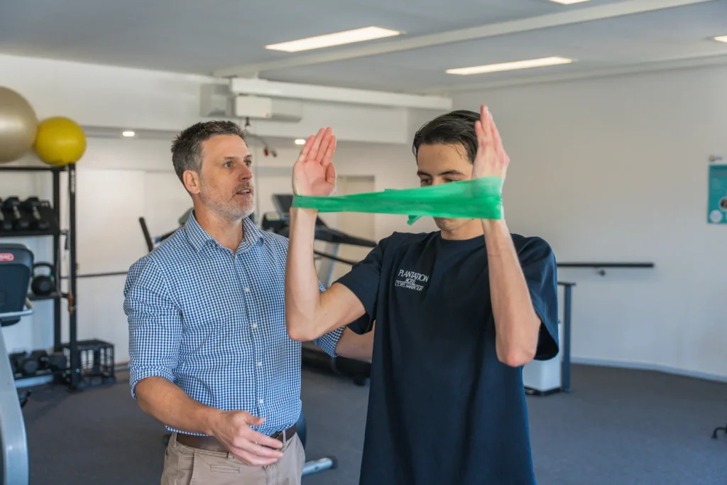 A physiotherapist assessing a sports injury on an athlete in a clinical setting